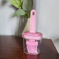 Pink heat-resistant silicone basting brush with transparent oil bottle on a wooden table - Silicone Pink
