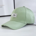 Close-up of light green twill cotton baseball cap with a white AD letter patch detail - Green + Black Label