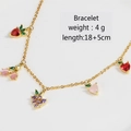 Detailed view of gold fruit charm bracelet with colorful cherry and peach zircons - Gold Mixed Fruit Bracelet