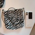 Mini bolso bandolera de lona con estampado de cebra y logotipo junto a un móvil plegado - Zebra Print