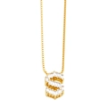 Close-up of golden letter S pendant with baguette-cut zircon stones on a box chain - Gold S
