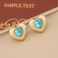 Golden heart stud earrings with concentric textures and central blue crystals on display - Lake Blue