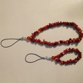 Detail of two red crushed stone phone charms with black lanyards on beige background - Red Crushed Stone Multi-Piece Set (款六)