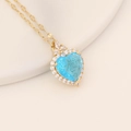 Elegant gold heart necklace with central blue crystal and sparkling diamond halo - Lake Blue