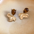 Detalle de pendientes de pez con cuerpo de resina y cola dorada sobre plato de cerámica - Poste de plata para pendientes-Dorado-Café