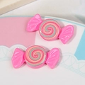 Macro detail of glossy pink resin candy charms with rainbow swirls for DIY hair accessories - Rose Red