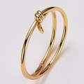 Close-up of golden knot bracelet with polished dual strands and a refined hinge clasp - Gold