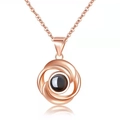 Macro view of rose gold swirl necklace featuring a center sphere projection stone - Rotating Circle Rose Gold