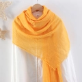 Yellow wrinkled cotton linen scarf with frayed edges hanging on a wooden hanger - Yellow