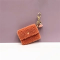 Detail of soft orange plush coin purse featuring a golden keychain and pink tassel - Single Piece / Orange