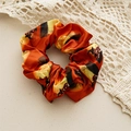 Detail eines Halloween-Haargummis aus Satin mit Kürbis- und Hexenhutmustern auf Orange - Kürbis-Muster / Halloween Orange