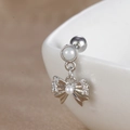 Vue macro de piercing d'hélix papillon argenté avec zircons et détail de perle sur céramique - Noeud de Perles