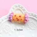 Close-up of a 1.6x3cm yellow and pink resin candy miniature for DIY dollhouse crafts - Taro Floss Roll