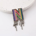 Macro view of a colorful rhinestone N-letter brooch with shimmering silver tassels - Letter N