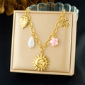 Collar de acero inoxidable dorado con colgantes de sol y hojas en joyero beige - Sol Hexagrama Hoja (N3715)
