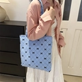 Bolso de hombro azul de lona con textura de rombos y pequeños lazos negros - Azul