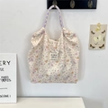 Detail of floral canvas tote bag with purple plaid handles and brand woven label - Colorful Star Puppy