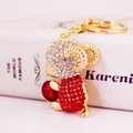 Golden zodiac sheep keychain with red and white crystals on a white book background - Individual Packaging / Red