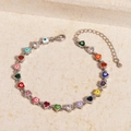Detail of multi-colored heart-shaped evil eye charms on a silver metal chain bracelet - 18K Gold / Multi-color Silver