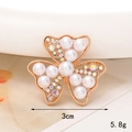 Detalle de dije de flor dorada con perlas y strass, mostrando el tamaño de 3cm - D1836 Flor Triangular