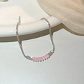 Close-up of pink zircon stones on a silver chain over a white ceramic surface - Single Row Pink