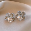 Polished silver floral earrings with layered petal design on soft silk background - Silver