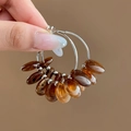 Macro detail of silver geometric hoop earrings with marbled brown resin beads - Coffee Round Resin Hoop (925 Sterling Silver Earring Post)