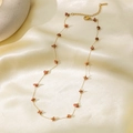 Elegant gold necklace set with natural red stones on luxury cream silk background - Irregular Red Stone Necklace - Gold