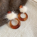 Macro shot of retro amber resin hoop earrings with soft cream faux fur pom-pom detail - Amber Circle With White Plush Ball (S925 Pin)
