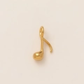 Macro detail of 18K gold plated stainless steel musical note pendant with polished finish - Music Note