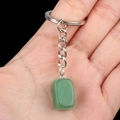Keyring with rectangular green stone pendant and silver metal chain held in hand - Green Aventurine
