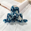 Blue and white patterned acetate claw clip with lace bow detail on a book background - Ink Blue Marble