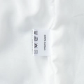 Detail shot of the 100% cotton fabric and garment care label on the white skirt set - S / White