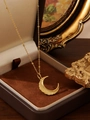 Golden crescent moon pendant necklace with bead chain on a vintage jewelry box - Wavy Moon (Gold ZHN2402)