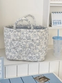 Detail of quilted corduroy floral storage basket with dual handles on a white shelf - Blue Floral
