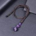 Macro shot of three natural amethyst stone beads on a dark brown braided rope necklace - Amethyst Necklace