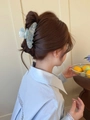 Pince à cheveux en acétate marbré bleu clair portée sur un chignon bas élégant - Pince en acétate à vagues d'eau / Bleu Azur