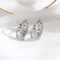Silver luxury hoop earrings with oval-cut cubic zirconia crystals on white silk background - Silver