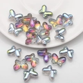 Macro view of butterfly-shaped glass beads in aurora finish for DIY jewelry crafting - Rose Red Green