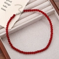 Detailed view of red beaded necklace with silver lobster clasp on a linen tray - Bead Chain Style (0181)