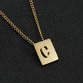 Primo piano di un ciondolo quadrato dorato con lettera C in 3D su una superficie nera - Oro Lettera C (Con Catena)