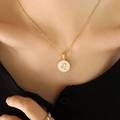 Leo zodiac necklace with white shell pendant and gold chain worn by a female model - Gold Leo