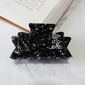 Pince à cheveux noire en acétate marbré avec nœud en strass sur un support blanc - Noir