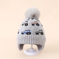 Detail view of winter knitted baby hat with car pattern and soft pompom on a stand - 3-8 Years / Gray