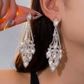Gros plan de boucles d'oreilles à pompons argentés avec fleurs de diamant et cristaux - Style Ovale Strass Argent (8# Tige en Argent)
