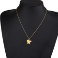 Dettaglio della collana con ciondolo a puzzle dorato su modello nero per gioielli di coppia - Piccolo Pezzo di Puzzle Oro