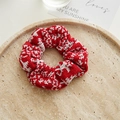 Detail of red and white houndstooth velvet scrunchies on a minimalist stone tray - Christmas Red Houndstooth