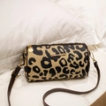 Cilindrische crossbodytas met luipaardprint, bruine riem en gouden metalen details - koffiekleur