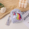 Unicorn coin purse with colorful print and tassel keychain on a wooden tray - Rainbow Letter Pony