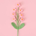 Detailansicht handgestrickter rosa Vergissmeinnicht-Blumen aus weicher Wollgarnware - Rosa